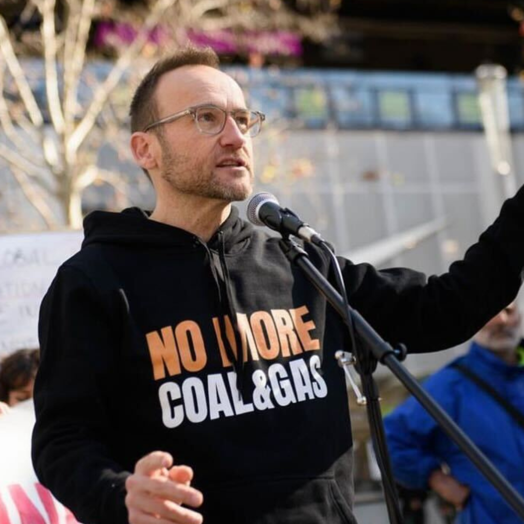 Adam Bandt wearing no new coal and gas hoodie speaking at rally 