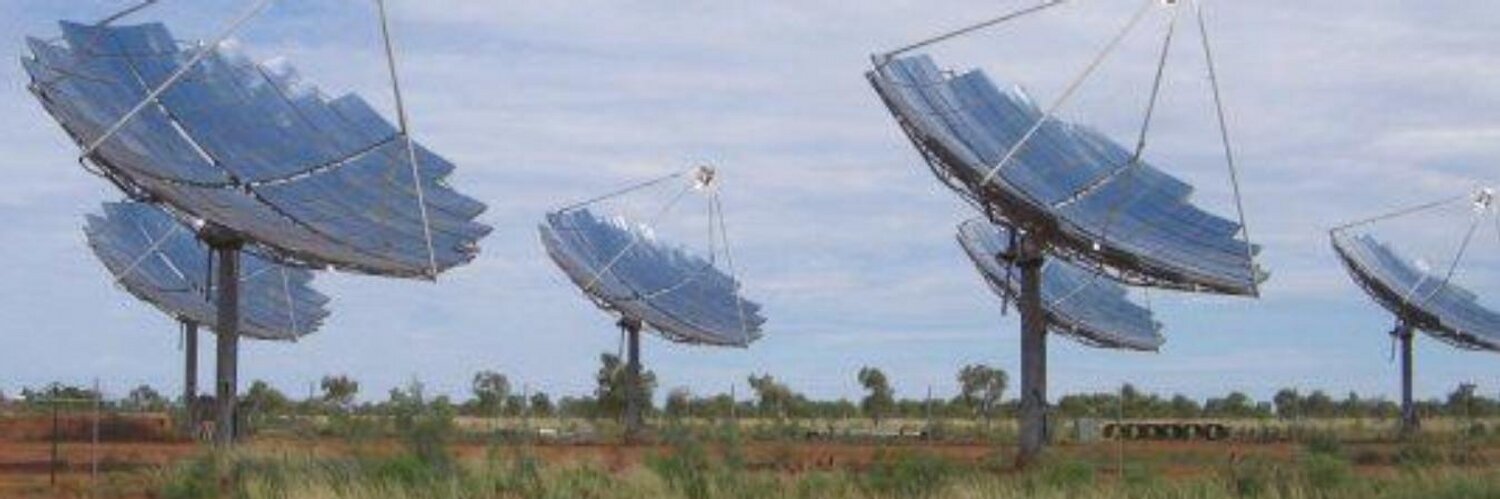 six dish shaped solar collectors in a field