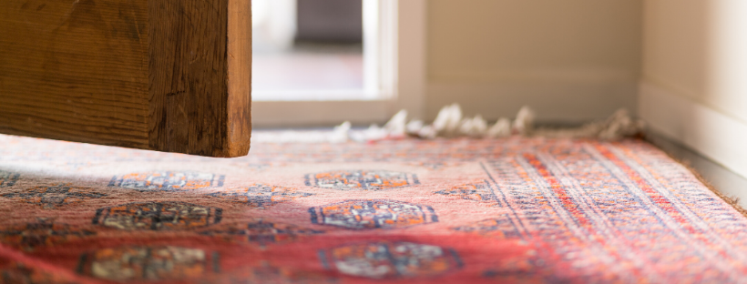 Bottom of an open door with red rug on the floor