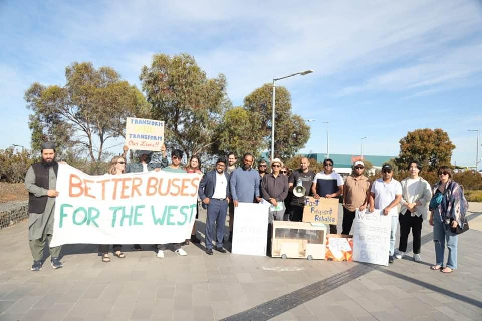 Better buses campaign stop with smiling people and a sign saying "better buses for the West"