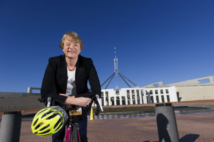 Senator Janet Rice with a bicycle in front of Parliament House in Canberra